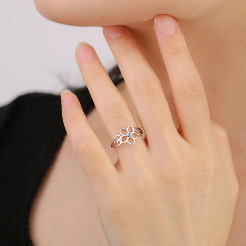 Sormus, jossa on viiden terälehden kukka ja hopeinen zirkoni