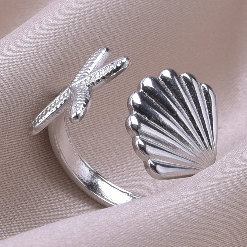 Sormus simpukoilla, meritähtellä ja kampasimpukalla hopeaa