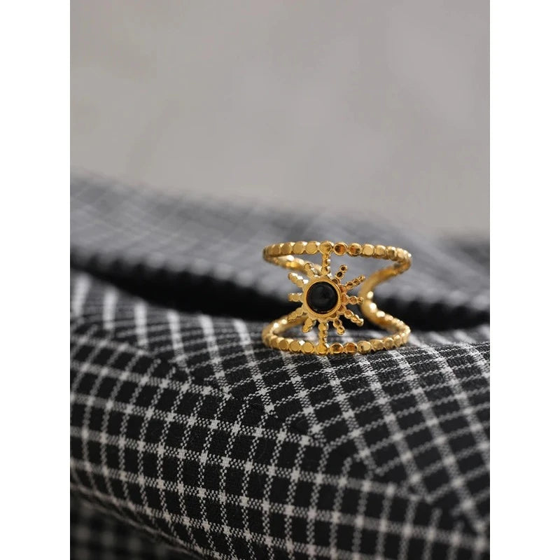 Aurinkosormus mustalla kivellä