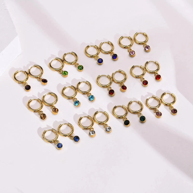 Renkaanmuotoiset korvakorut syntymäkivellä ja zirkonilla