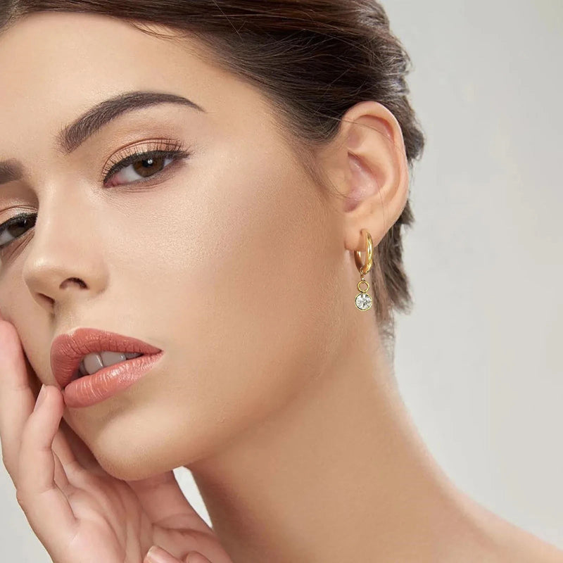 Renkaanmuotoiset korvakorut syntymäkivellä ja zirkonilla