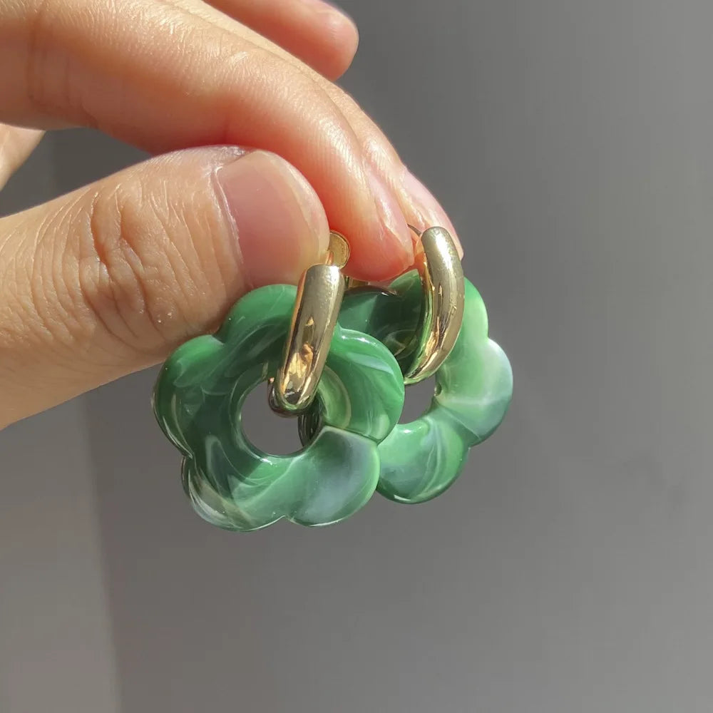 Korvakorut, joissa on kukkakuvioinen resiinisormus