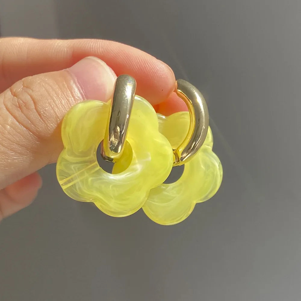 Korvakorut, joissa on kukkakuvioinen resiinisormus