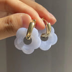 Korvakorut, joissa on kukkakuvioinen resiinisormus