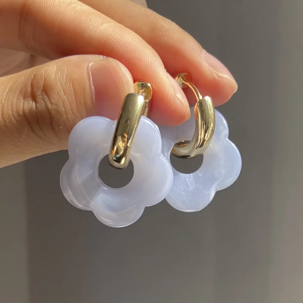 Korvakorut, joissa on kukkakuvioinen resiinisormus