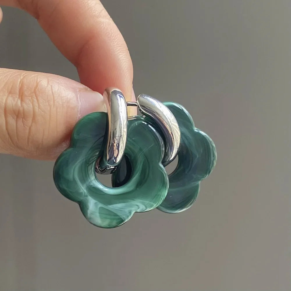 Korvakorut, joissa on kukkakuvioinen resiinisormus