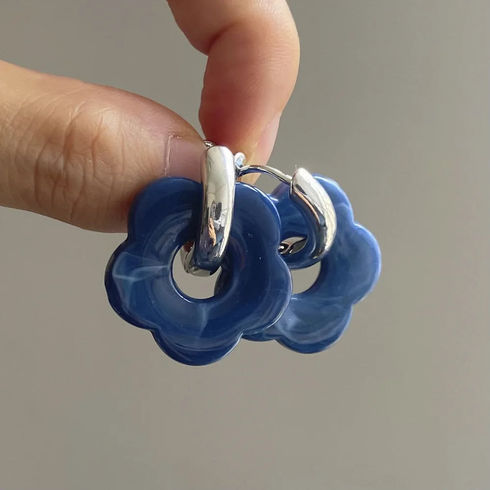 Korvakorut, joissa on kukkakuvioinen resiinisormus