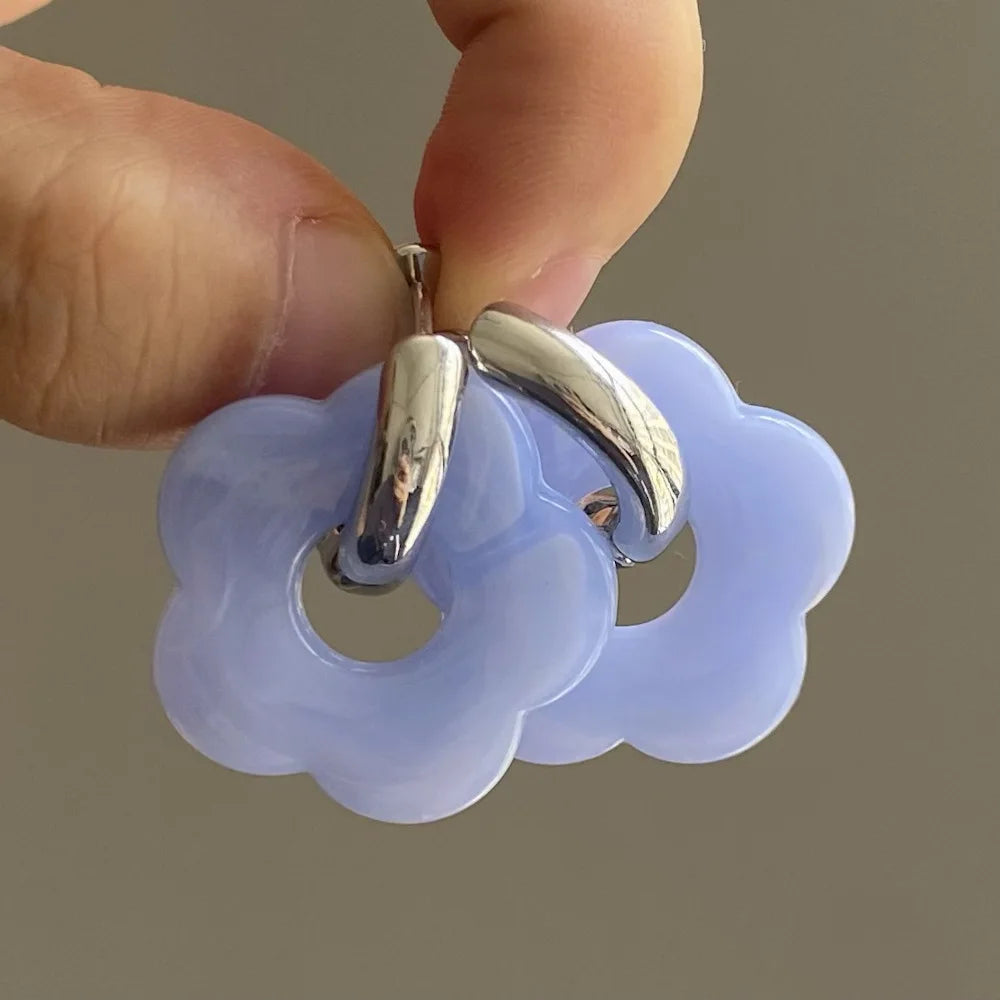 Korvakorut, joissa on kukkakuvioinen resiinisormus