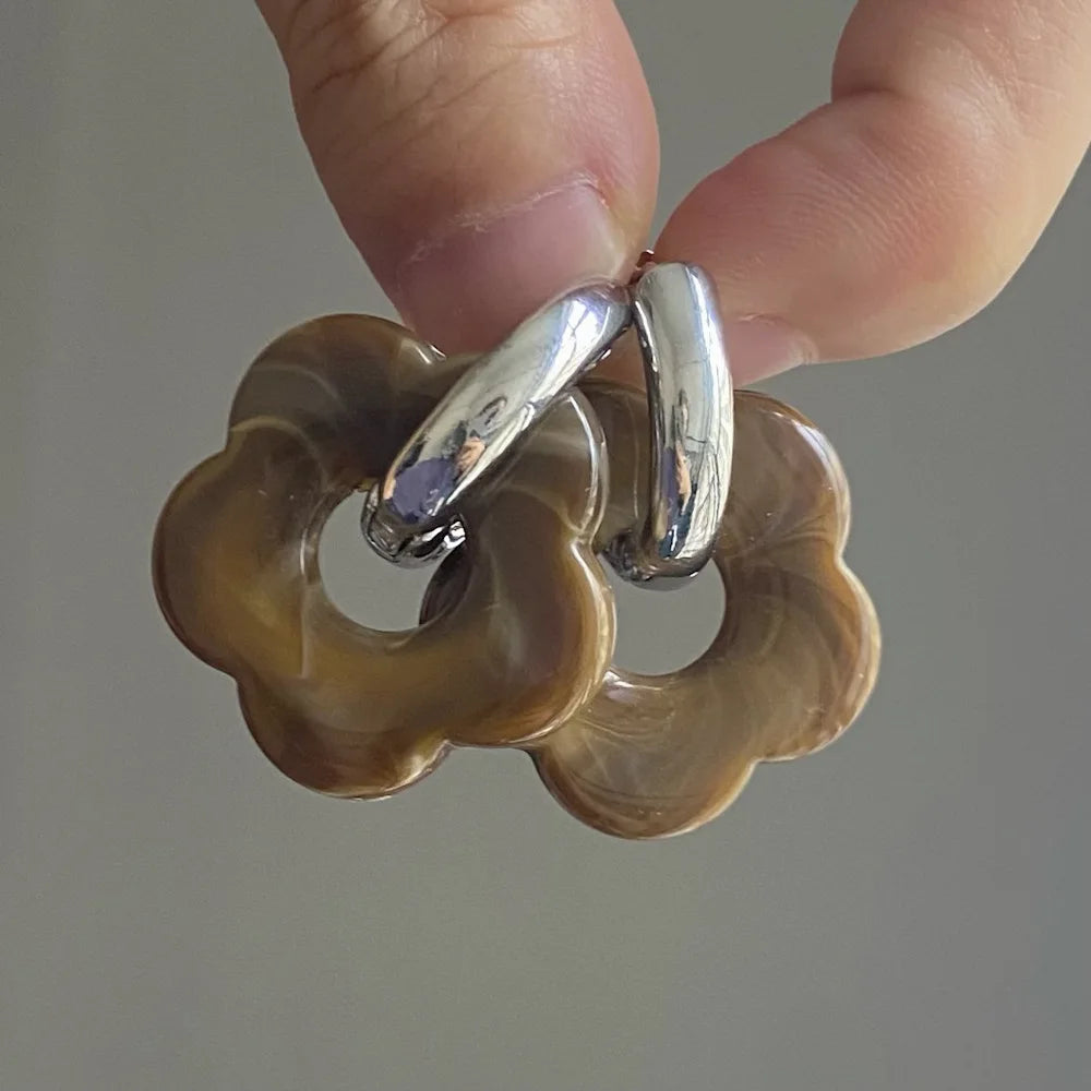 Korvakorut, joissa on kukkakuvioinen resiinisormus