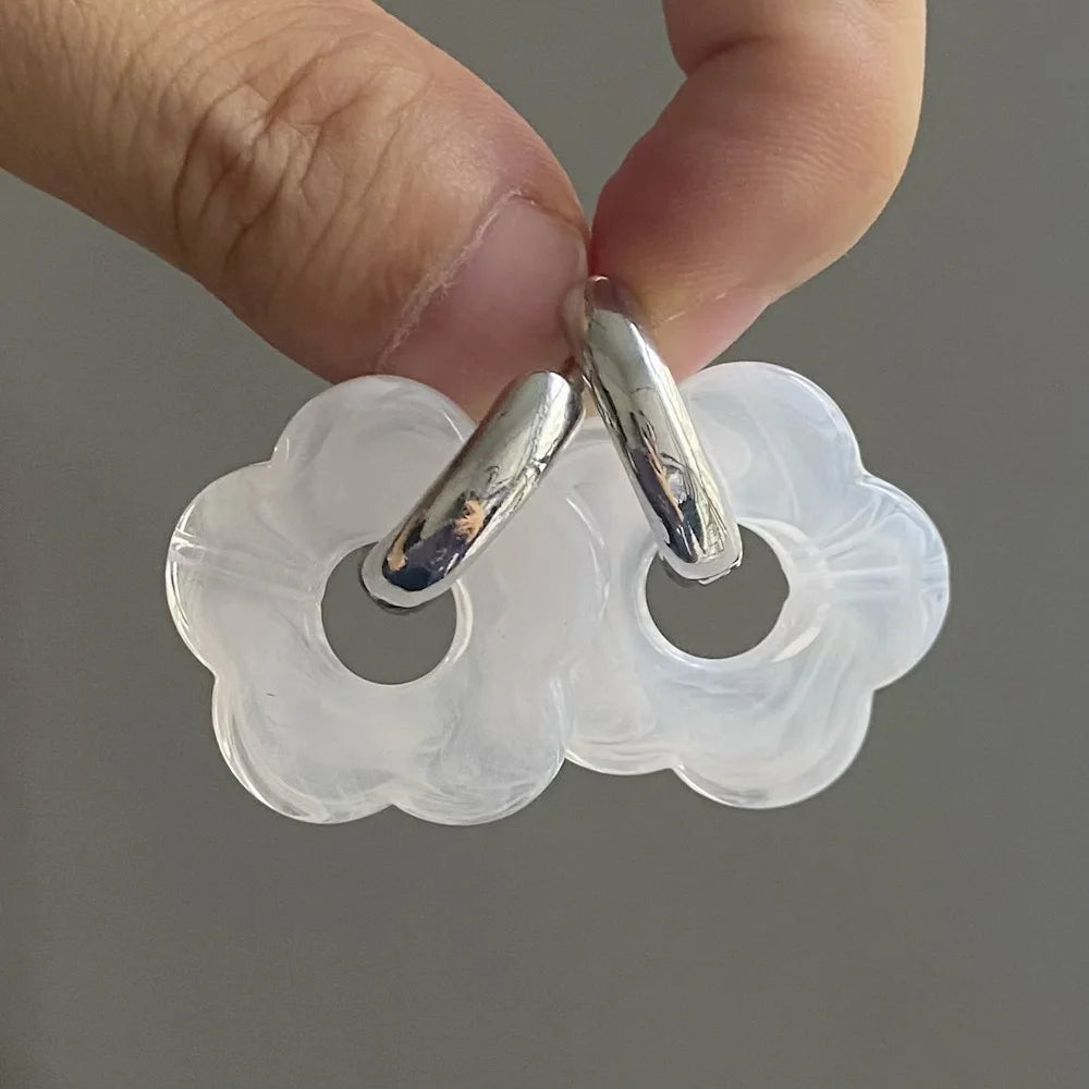 Korvakorut, joissa on kukkakuvioinen resiinisormus