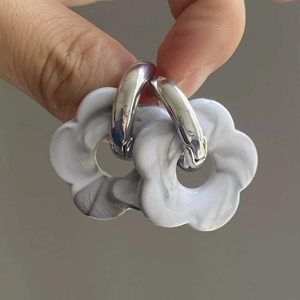 Korvakorut, joissa on kukkakuvioinen resiinisormus