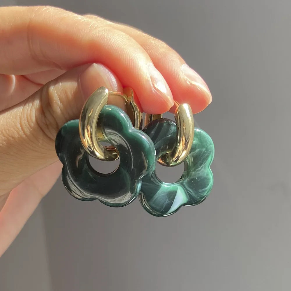 Korvakorut, joissa on kukkakuvioinen resiinisormus