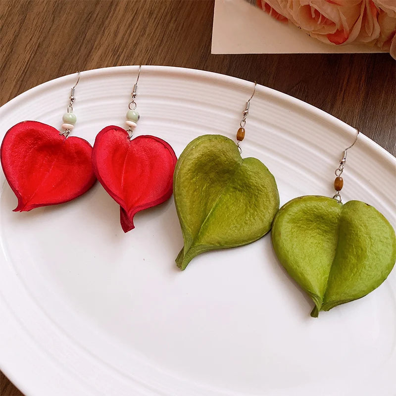 Riipuvat korvakorut värillisellä lehdellä