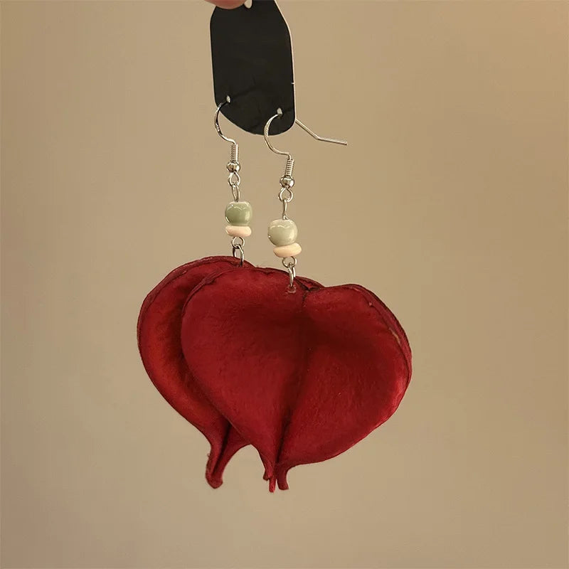 Riipuvat korvakorut värillisellä punaisella lehdellä