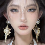 Riipuvat korvakorut simpukkakuorella