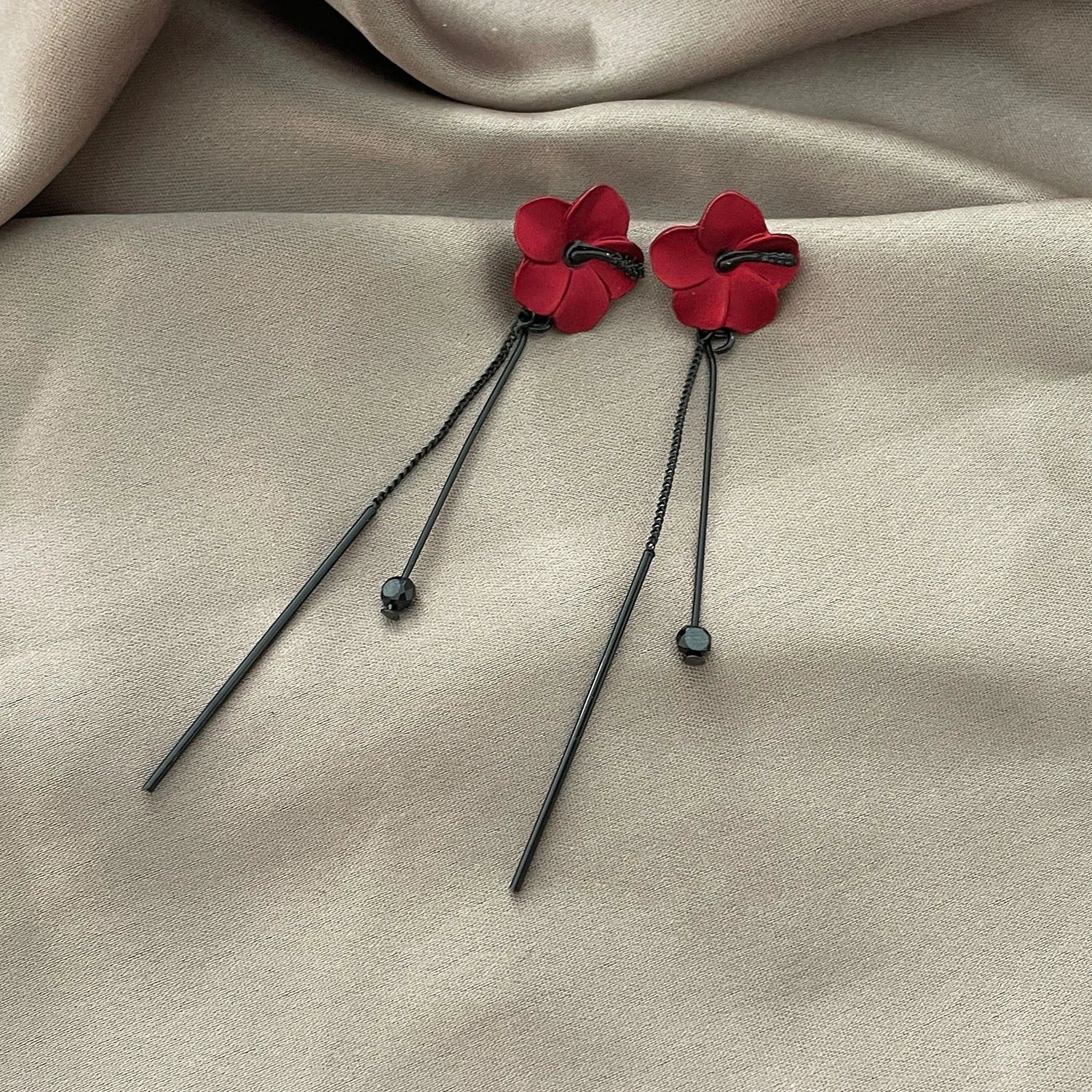 Punainen kukka ja punainen ketju roikkuvat korvakorut
