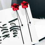 Punainen kukka ja punainen ketju roikkuvat korvakorut