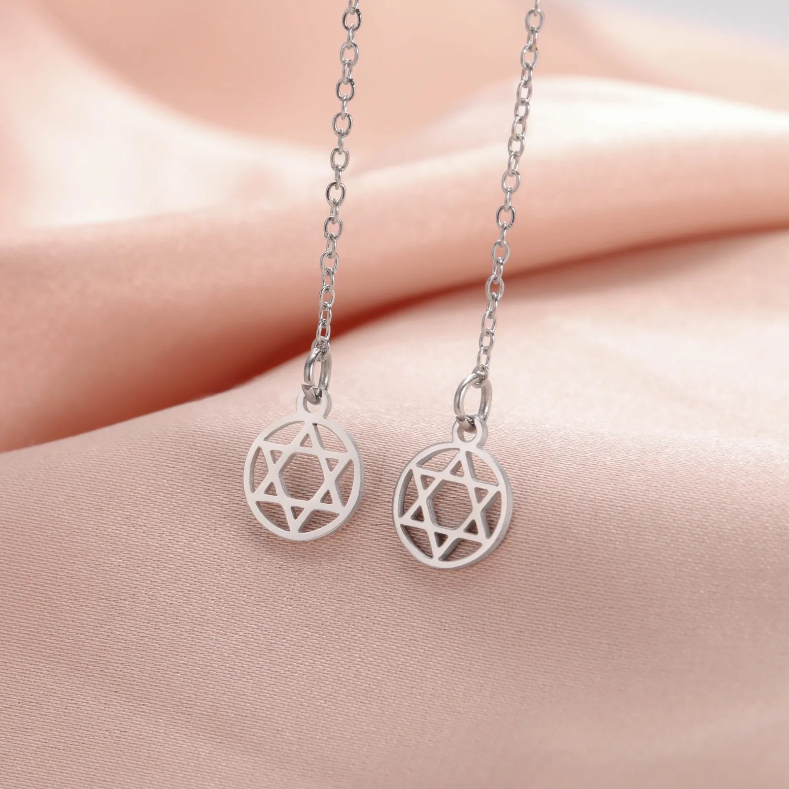 Pyöreät pitkät roikkuvat korvakorut, joissa on <span data-glossary-id="etoile-de-david">Daavidin tähti</span>, juutalainen symboli hopeassa