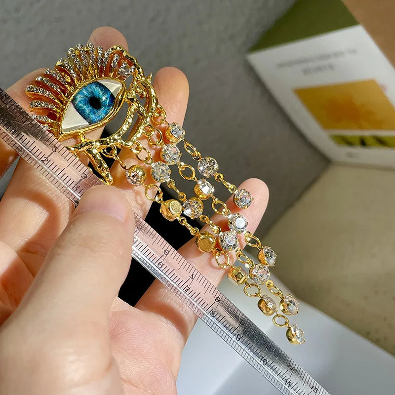 Siniset silmät ja strassikoristeiset roikkuvat korvakorut