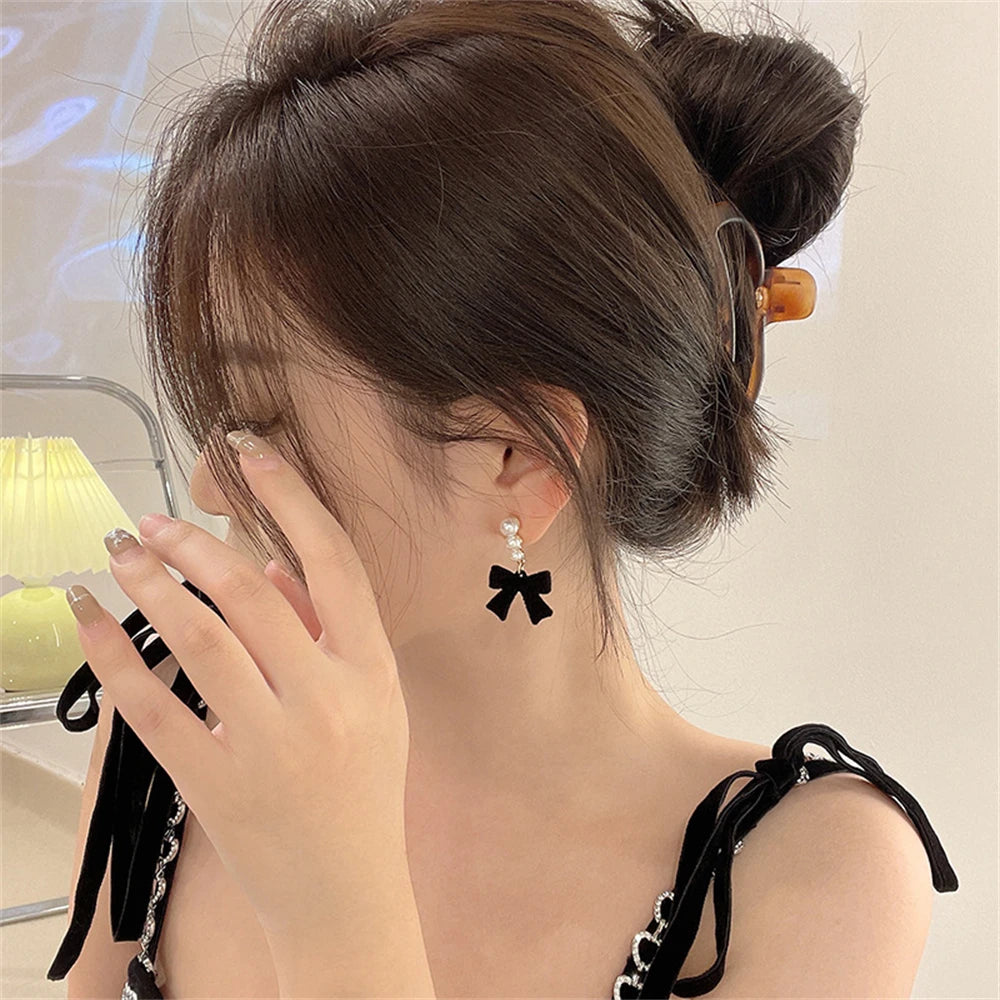 Riipuvat korvakorut helmillä ja mustilla nauhoilla