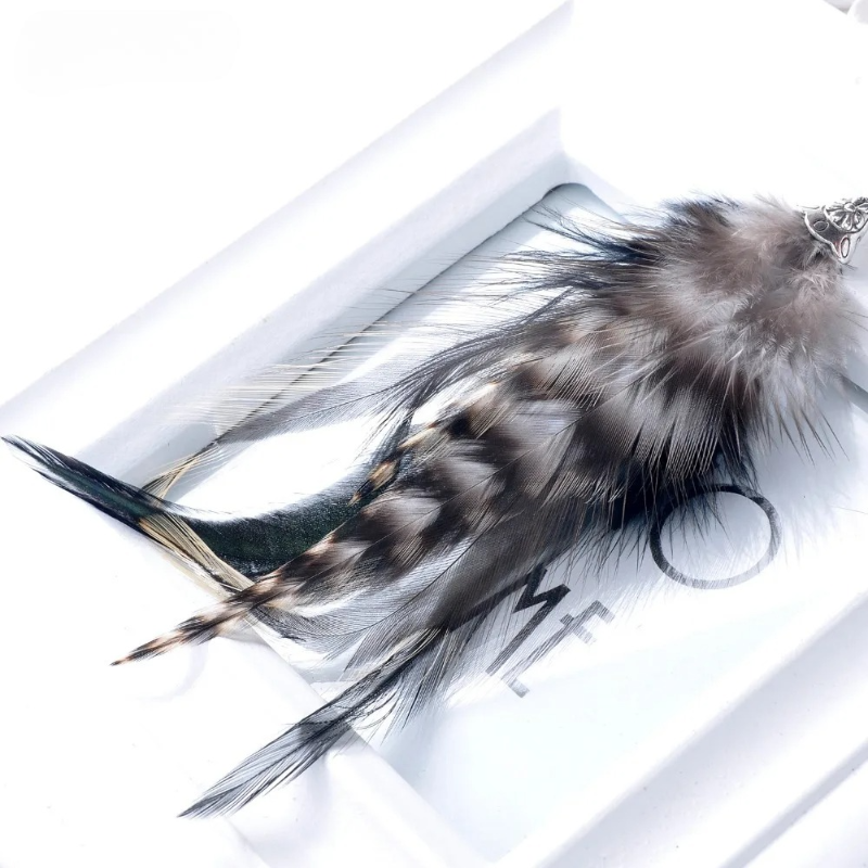 Riipuvat korvakorut metson höyhenillä