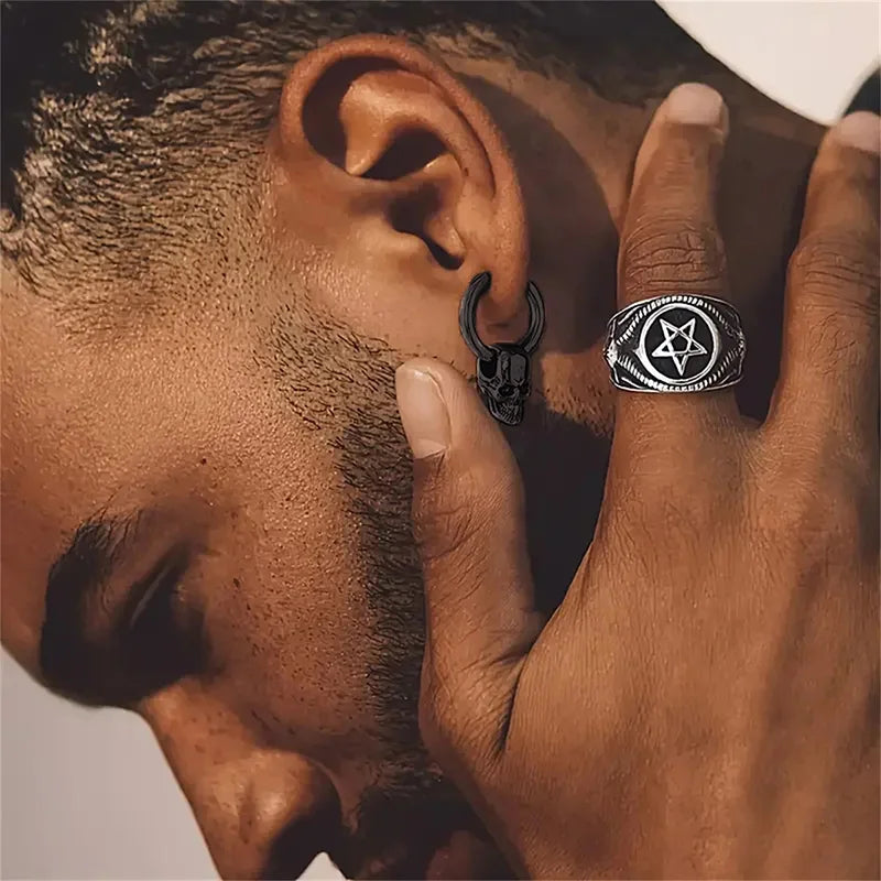 Miesten mustat roikkuvat korvakorut, joissa pääkallo