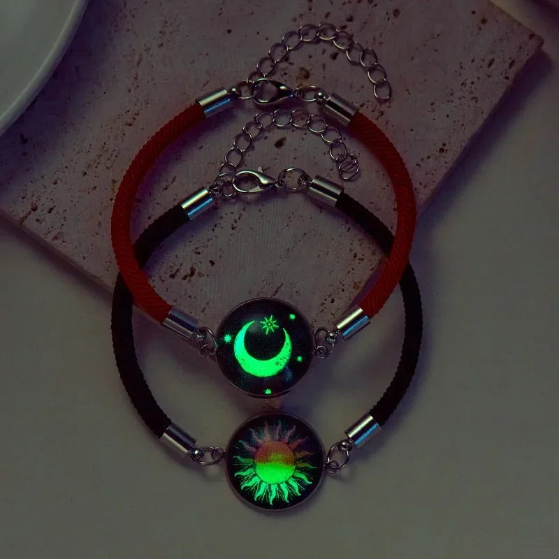 Rannekoru punaisella ja mustalla hehkuvalla puolikuulla ja auringolla