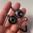 Rannekoru punaisella ja mustalla hehkuvalla puolikuulla ja auringolla