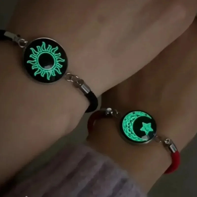 Rannekoru punaisella ja mustalla hehkuvalla puolikuulla ja auringolla