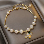 Rannekoru valkoisilla helmillä ja mehiläisellä