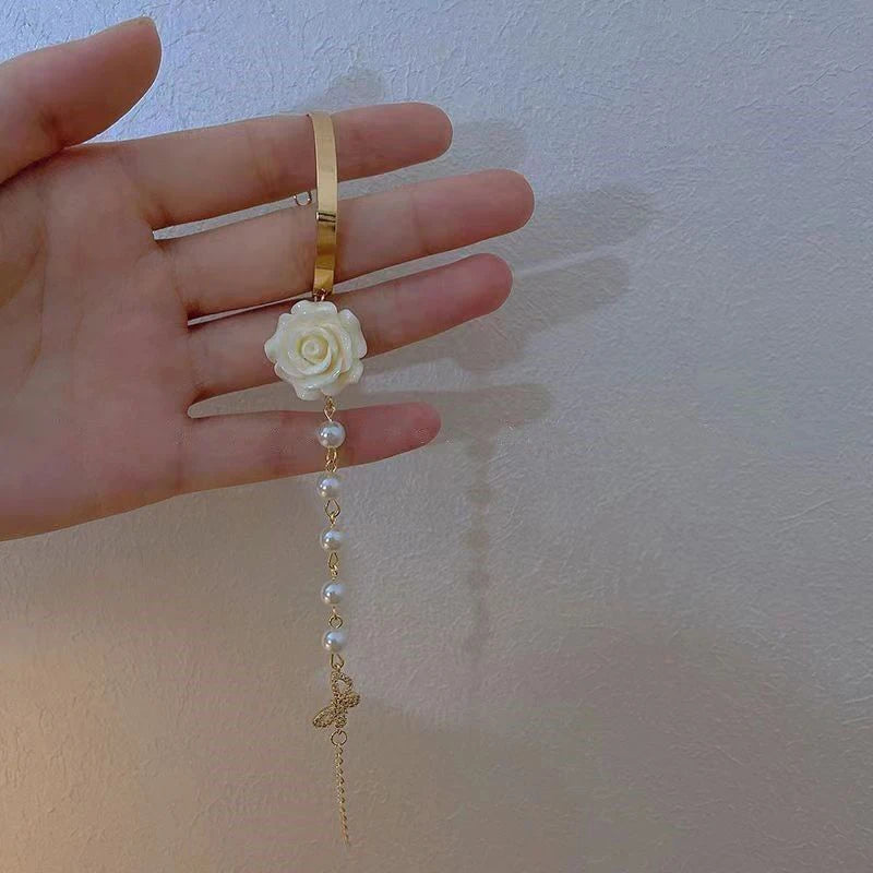 Rannekoru jossa helmet ja valkoinen ruusukukka