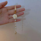 Rannekoru jossa helmet ja valkoinen ruusukukka