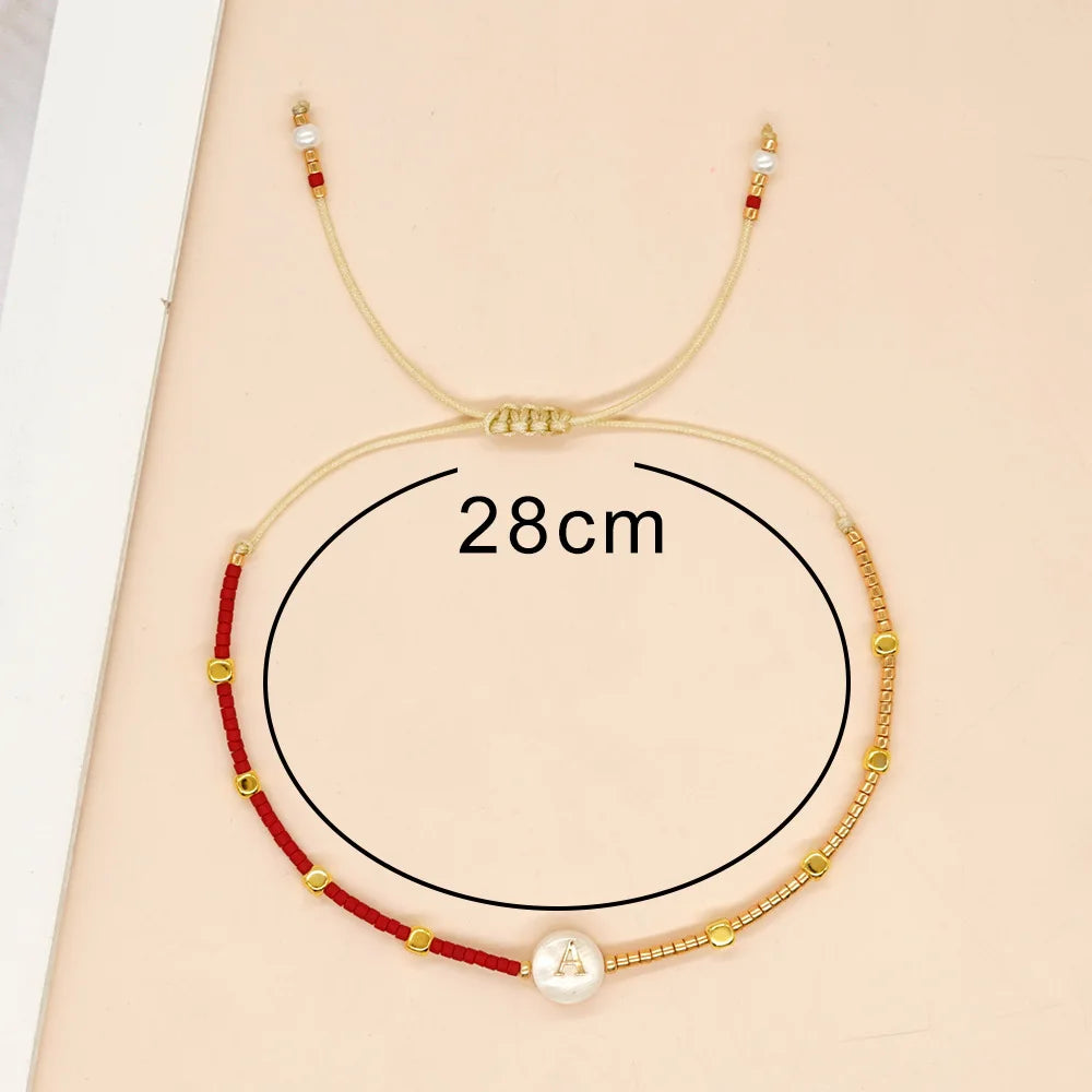 Kaksivärinen rannekoru alkukirjaimella