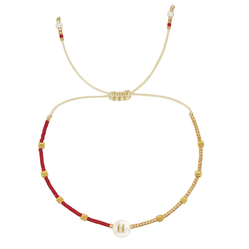 Kaksivärinen rannekoru alkukirjaimella h