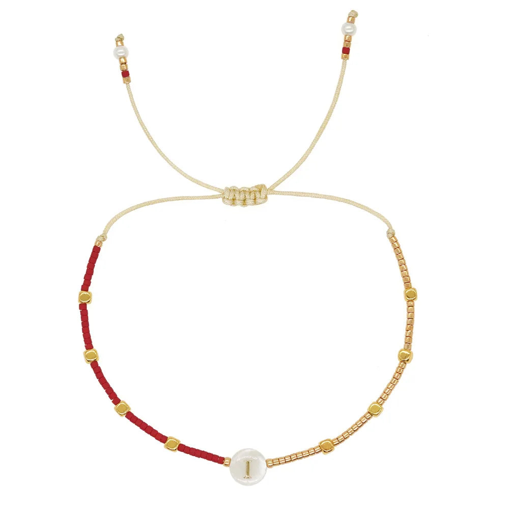 Kaksivärinen rannekoru alkukirjaimella i