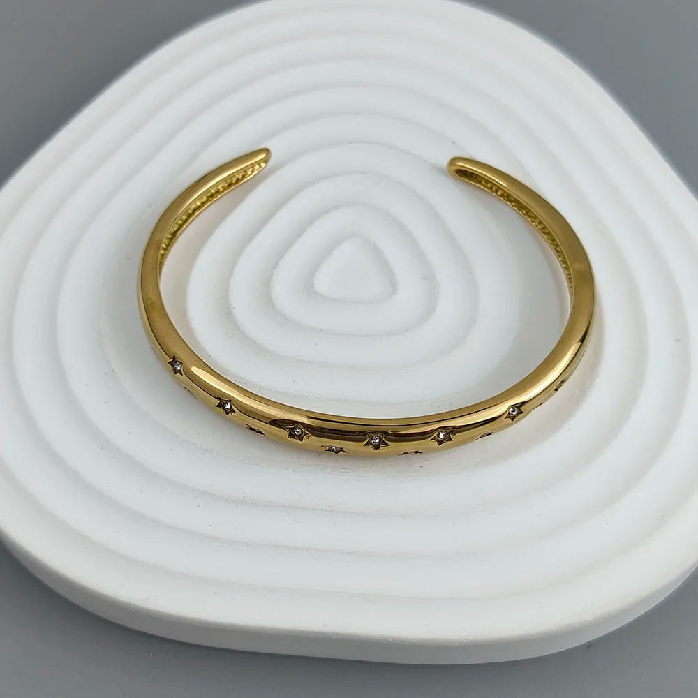 Elegantti rannekoru tähtitaivaan kultaisilla tähdillä