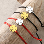 Naru rannekoru punaisella ja kultaisella nelilehtisellä apilalla onnenkoruna