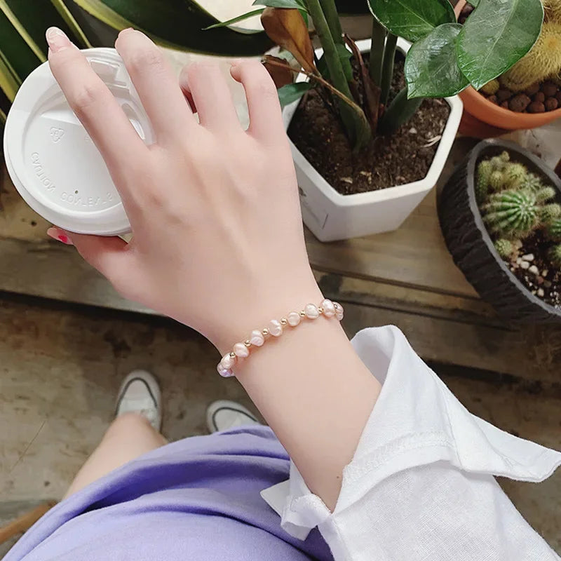 Rannekoru, jossa on vaaleanpunaisia helmiä