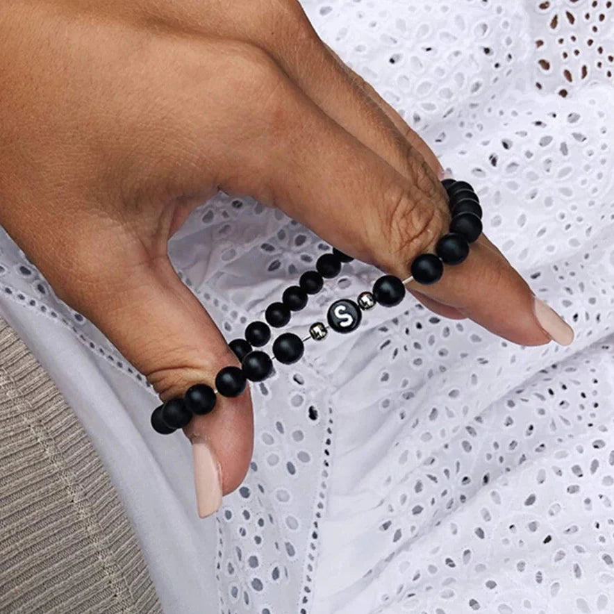 Musta rannekoru alkukirjain