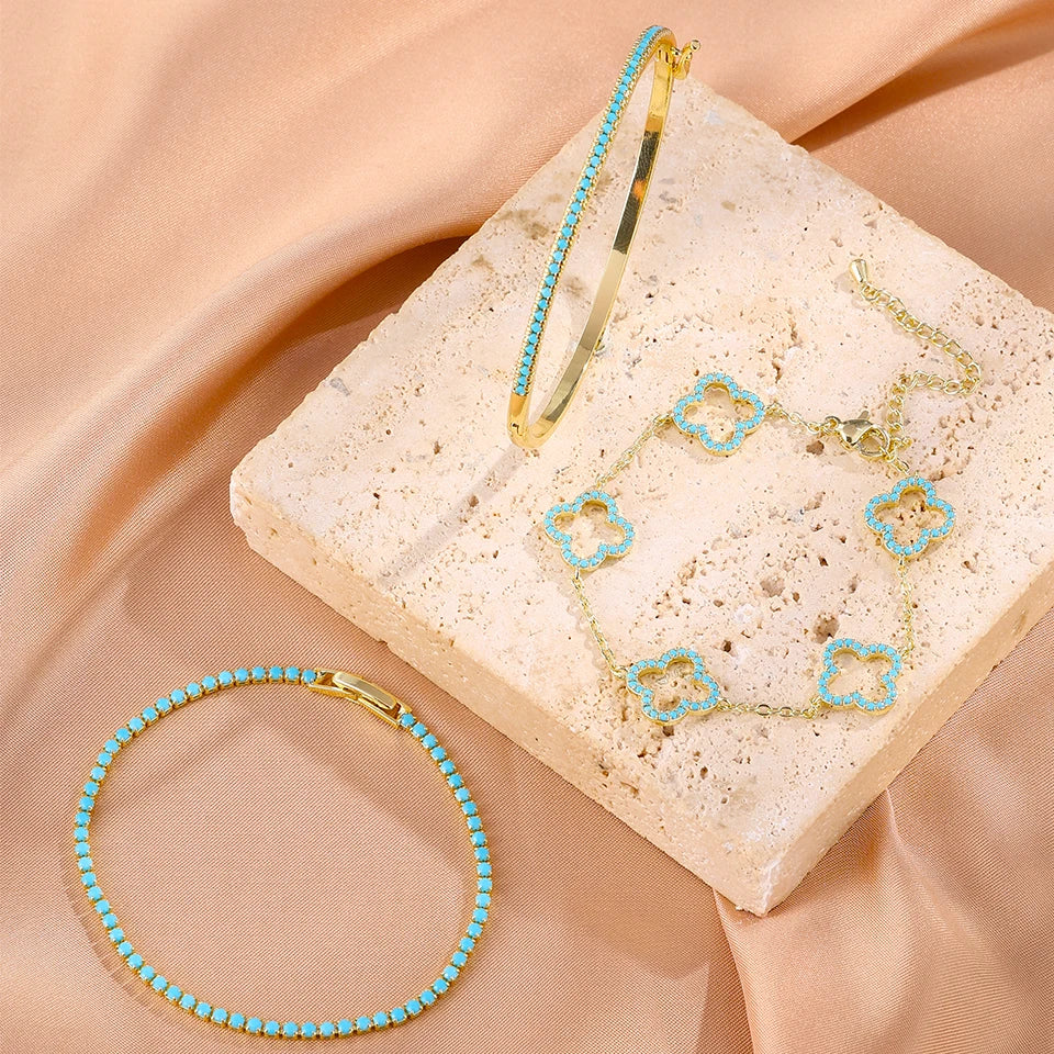 3 kappaleen rannekorusetti, jossa siniset zirkonilla koristellut nelilehtiset apilat