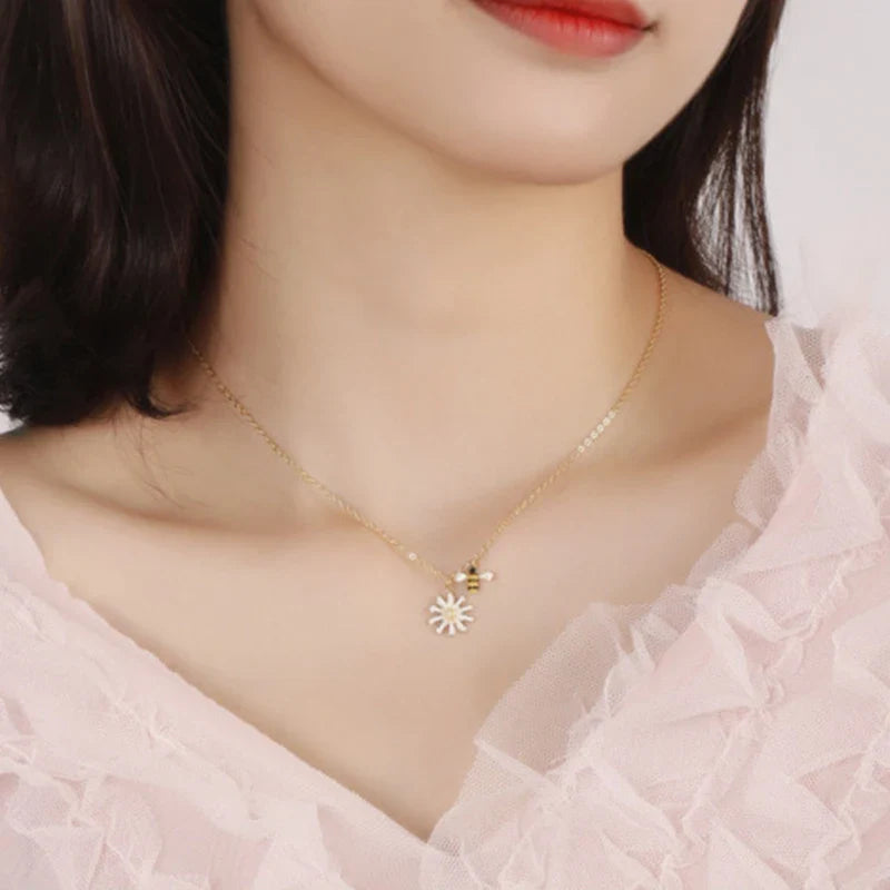 Kaulakoru mehiläisriipuksella ja päivänkakkaran kukalla