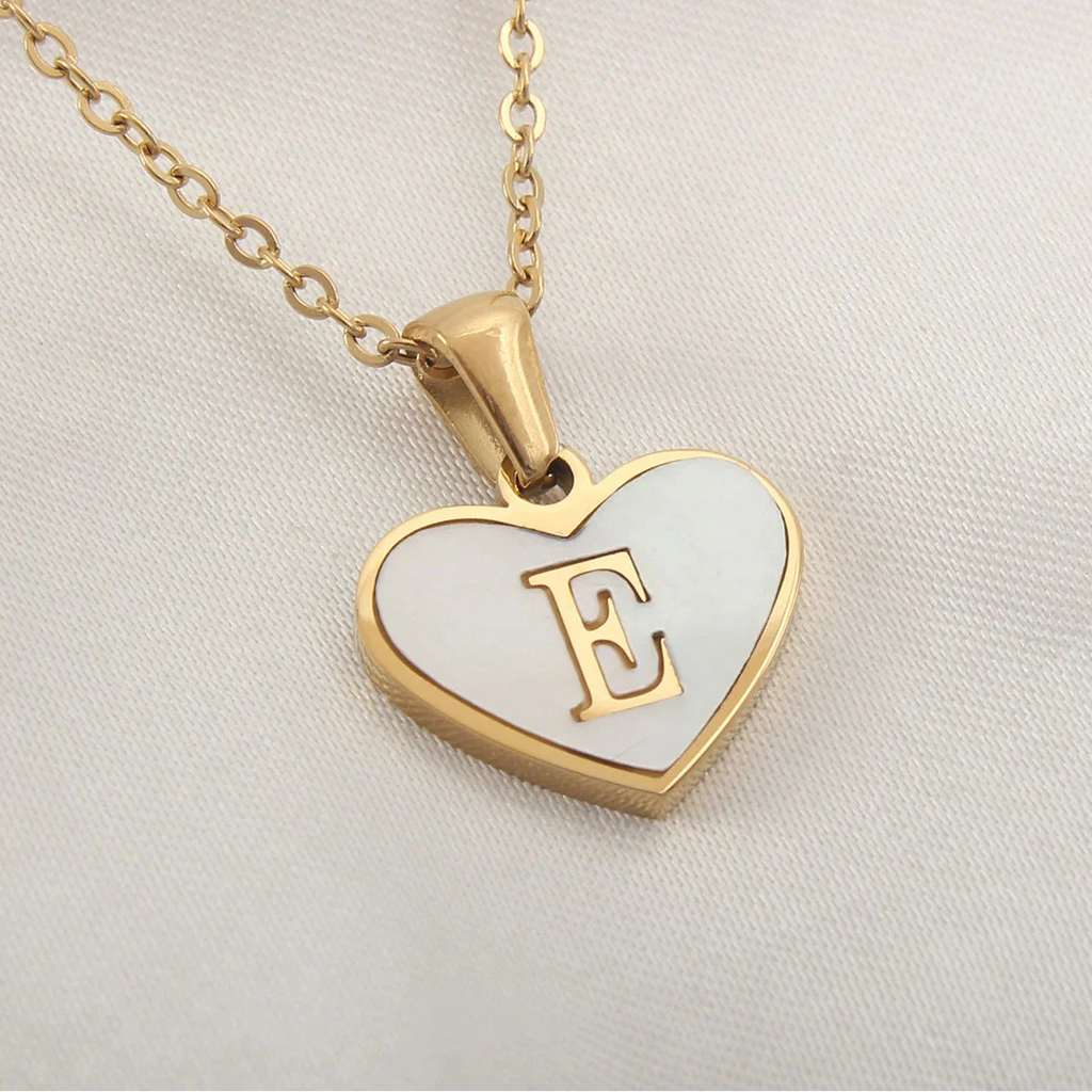Kaulakoru, jossa valkoinen sydänriipus ja kirjain e