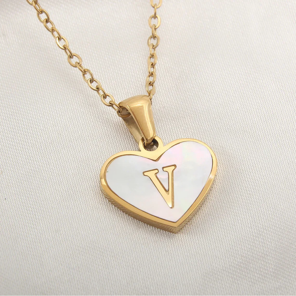 Kaulakoru, jossa valkoinen sydänriipus ja kirjain v