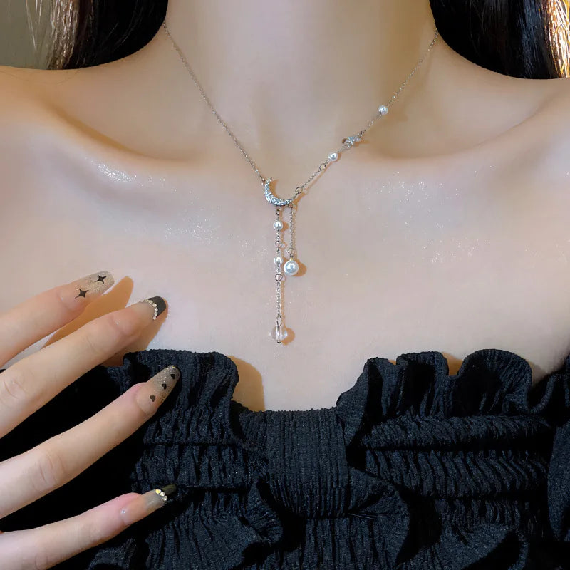 Kaulakoru, jossa on sirppikuun ja helmien riipus