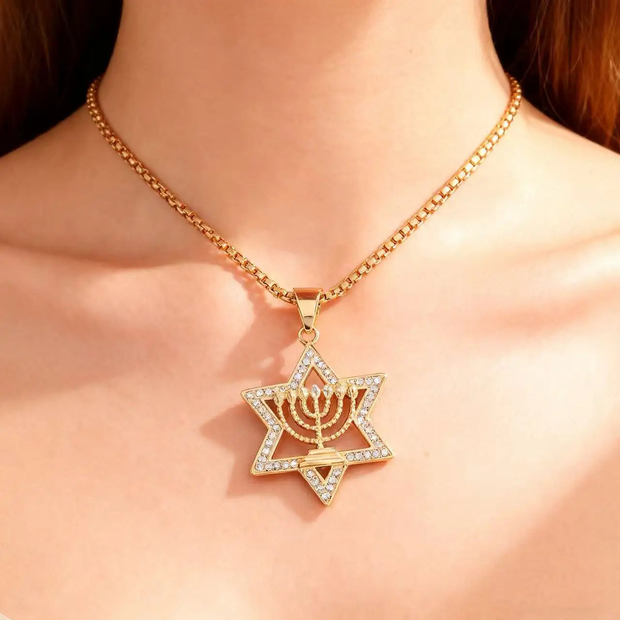 Kaulakoru, jossa riipus <span data-glossary-id="étoile de David">Daavidin tähti</span> ja juutalaisen identiteetin symboli <span data-glossary-id="Menorah">Menora</span>, kultaa