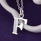 Pitkä kaulakoru, jossa nimikirjainriipus f