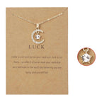 Kaulakoru, jossa on kuun muotoinen riipus ja syntymäkivi strassikoristein