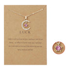 Kaulakoru, jossa on kuun muotoinen riipus ja syntymäkivi strassikoristein