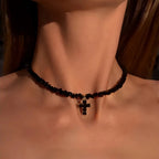 Kaulakoru, jossa musta kimalteleva risti choker-riipuksena