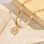 Kaulakoru, jossa nelilehtinen apilan muotoinen onnenamuetti ja zirkoni